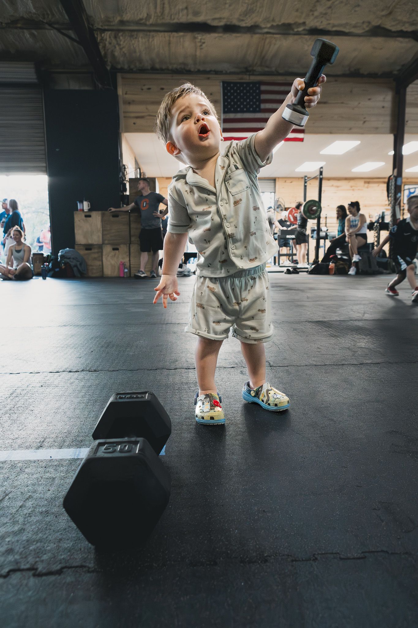 Toddler cheering in the middle of a CrossFit gym