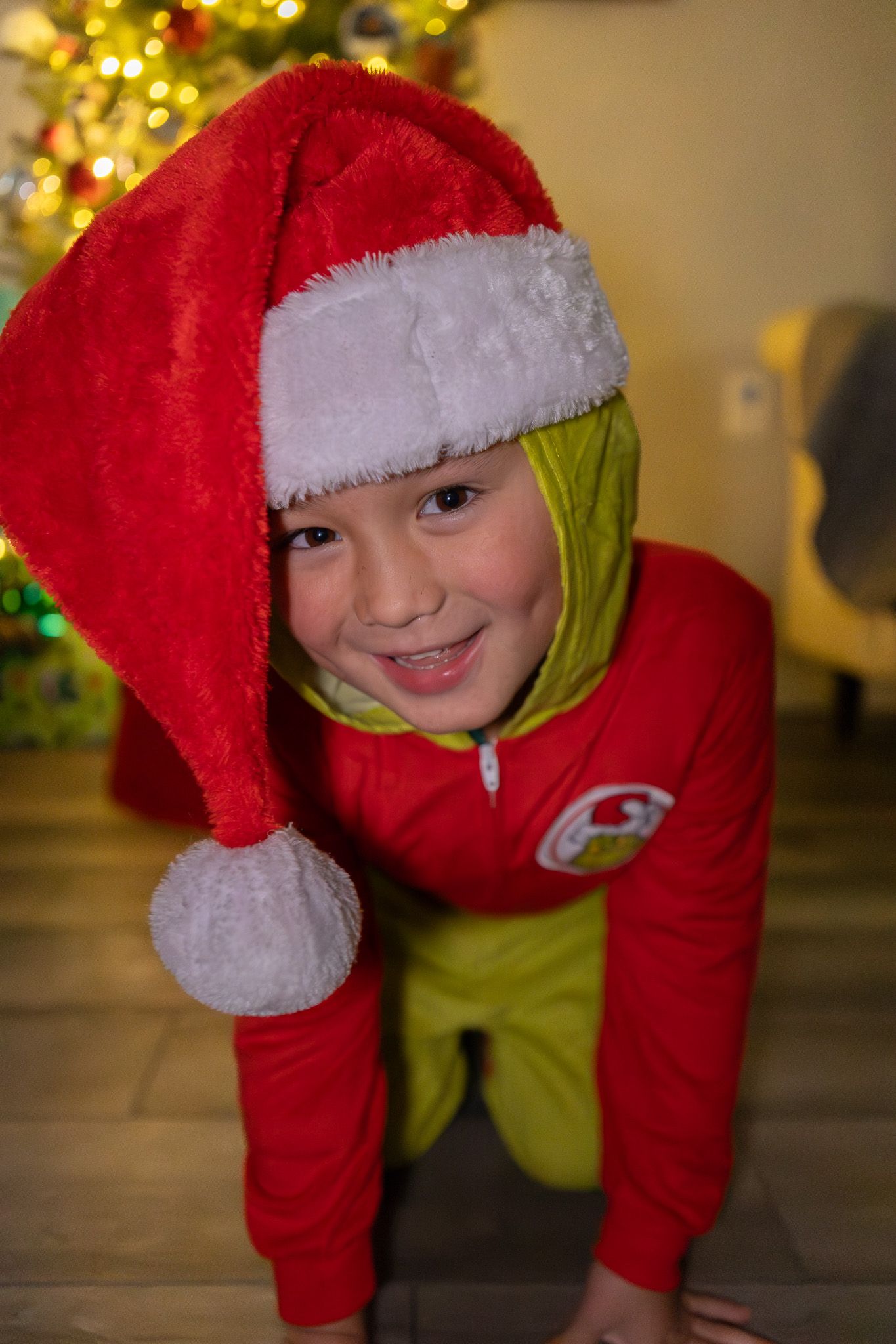 Boy in a Santa hat smiling at the camera during Christmas photos