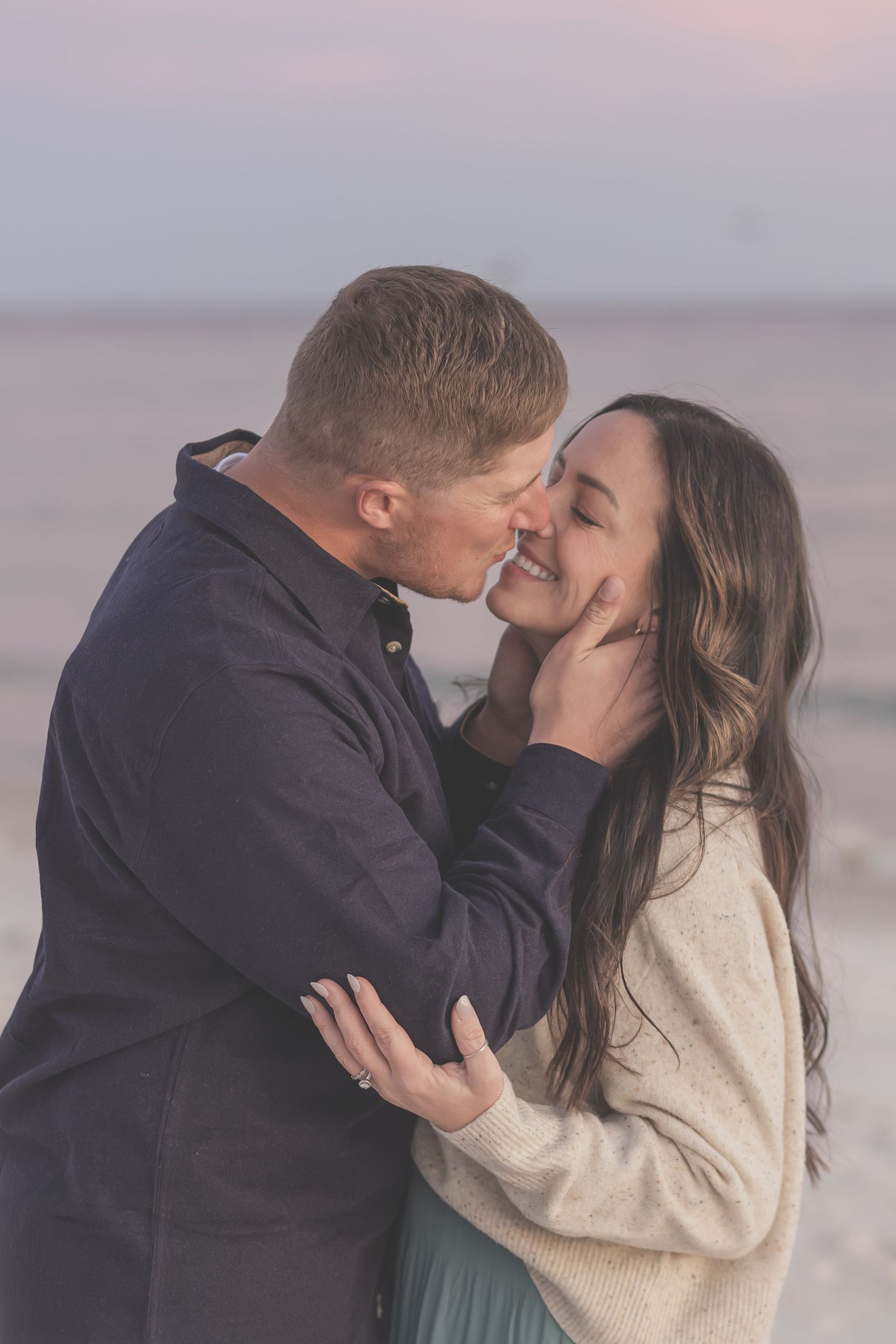 Couple sharing a kiss on Pensacola Beach at sunset
