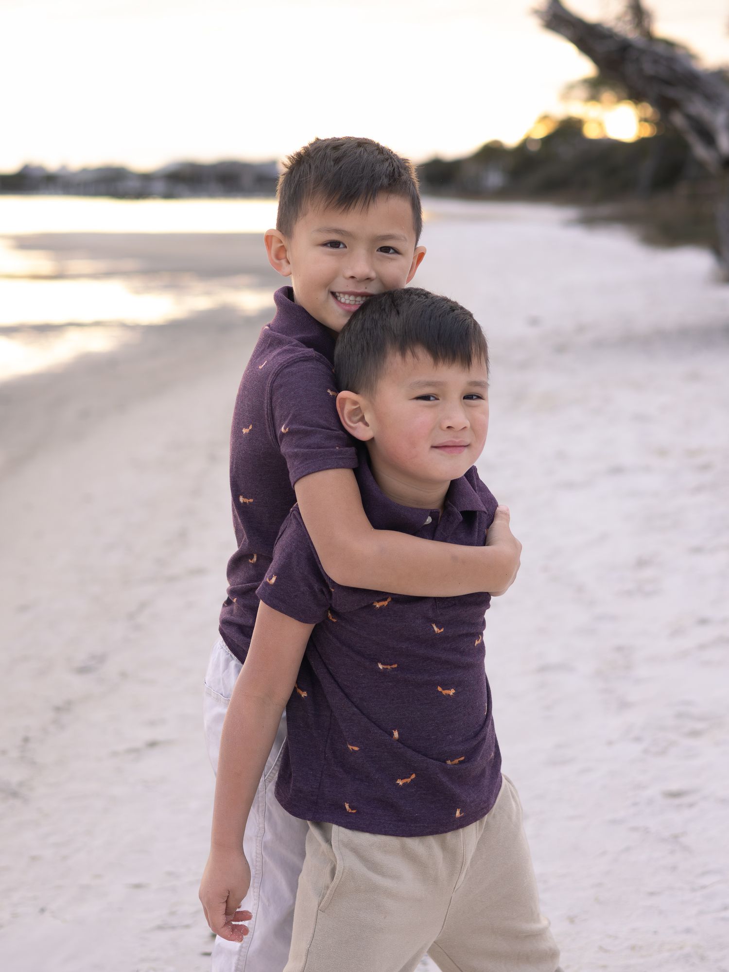 Big brother giving his little brother a piggyback ride on the beach