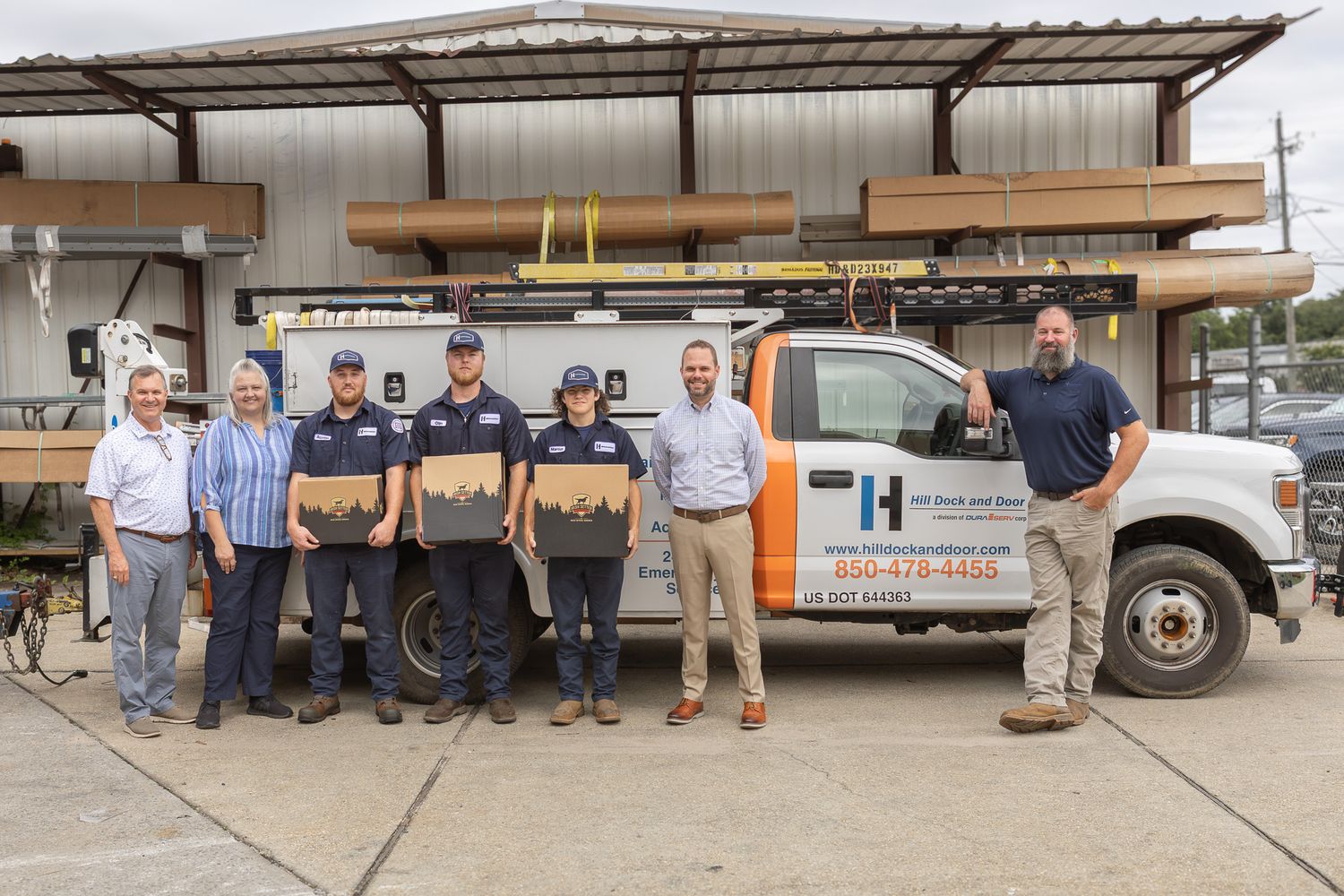 Company team group photo in front of their work trucks