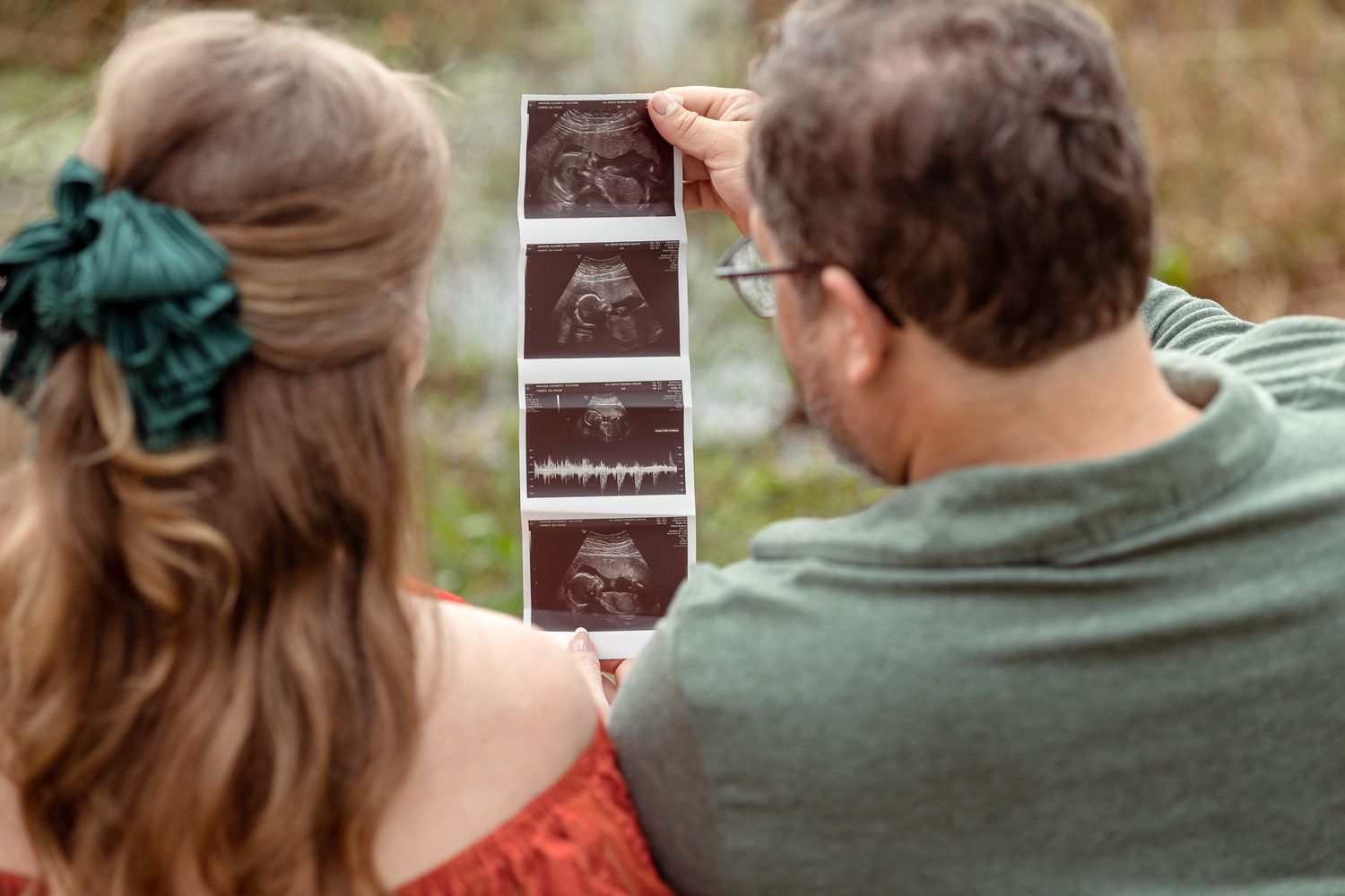 Expecting couple looking at ultrasound photos together at Bear Lake, Milton FL