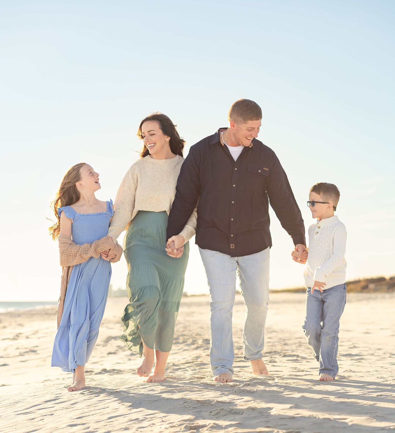 Family of four walking together on the beach