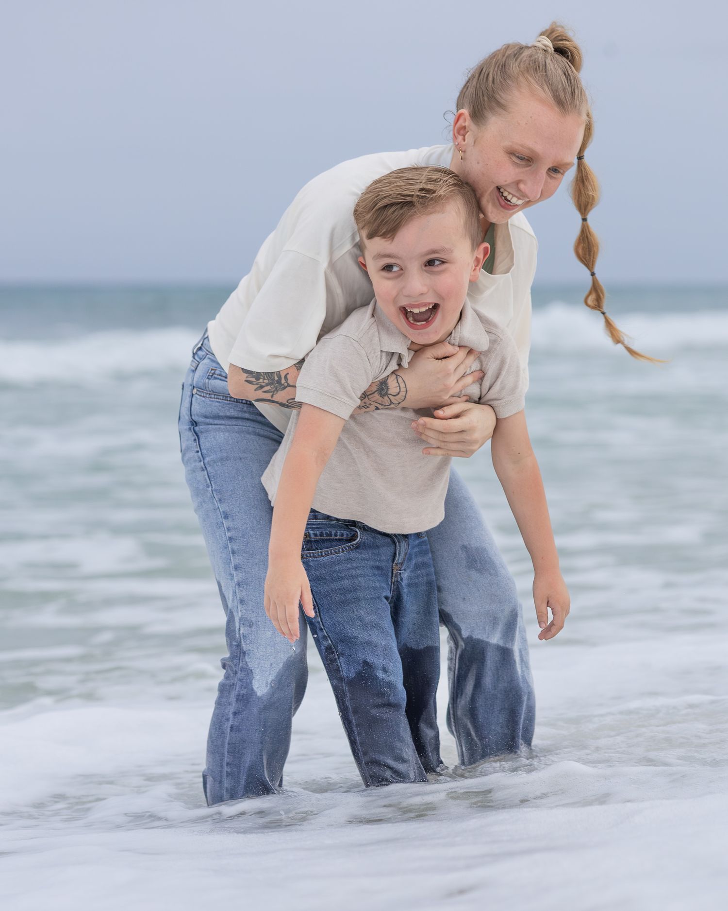 Mom giving her son a piggyback ride in the surf