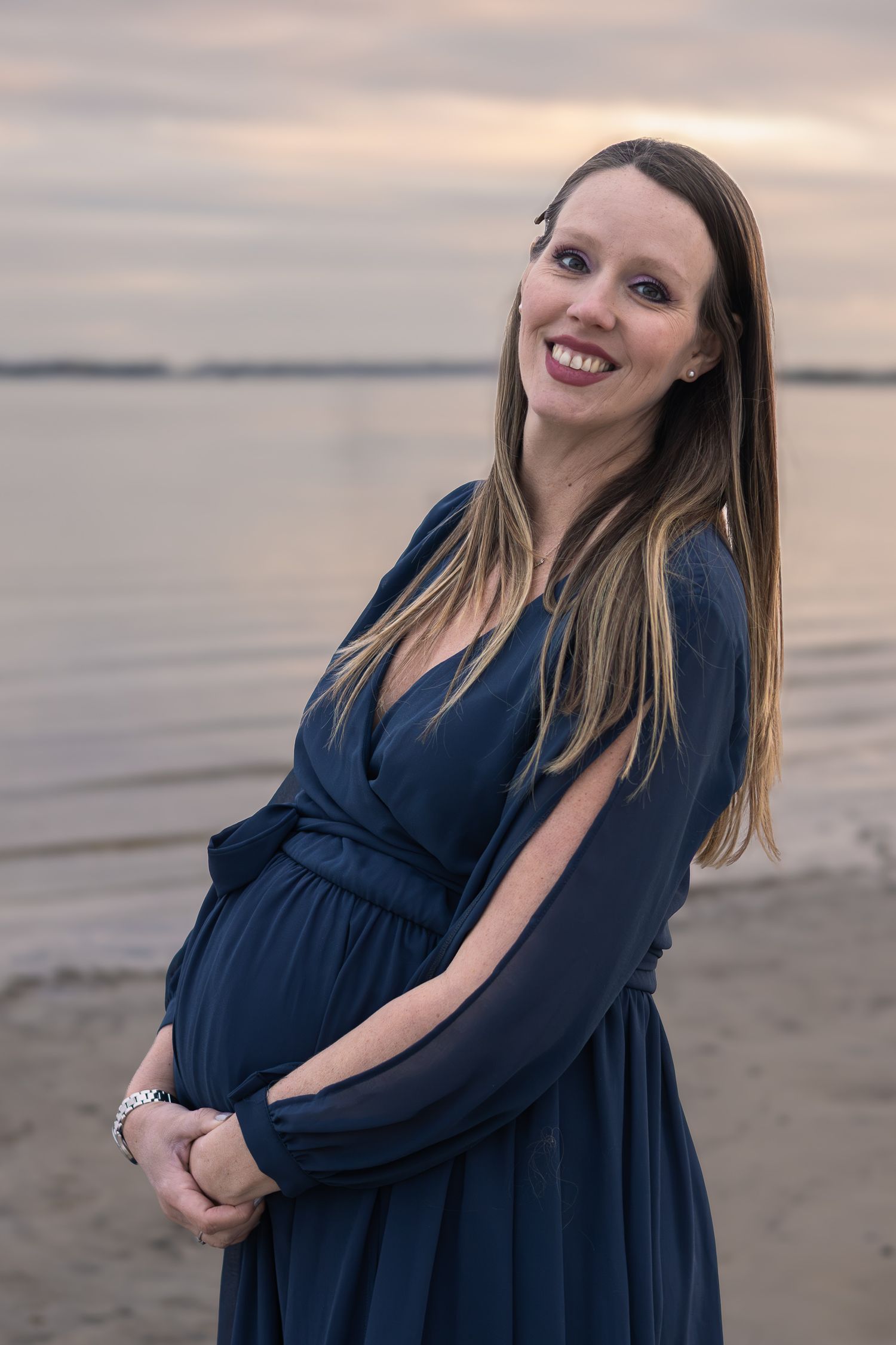 Smiling pregnant mom in a flowing navy dress at sunset, Pensacola maternity session