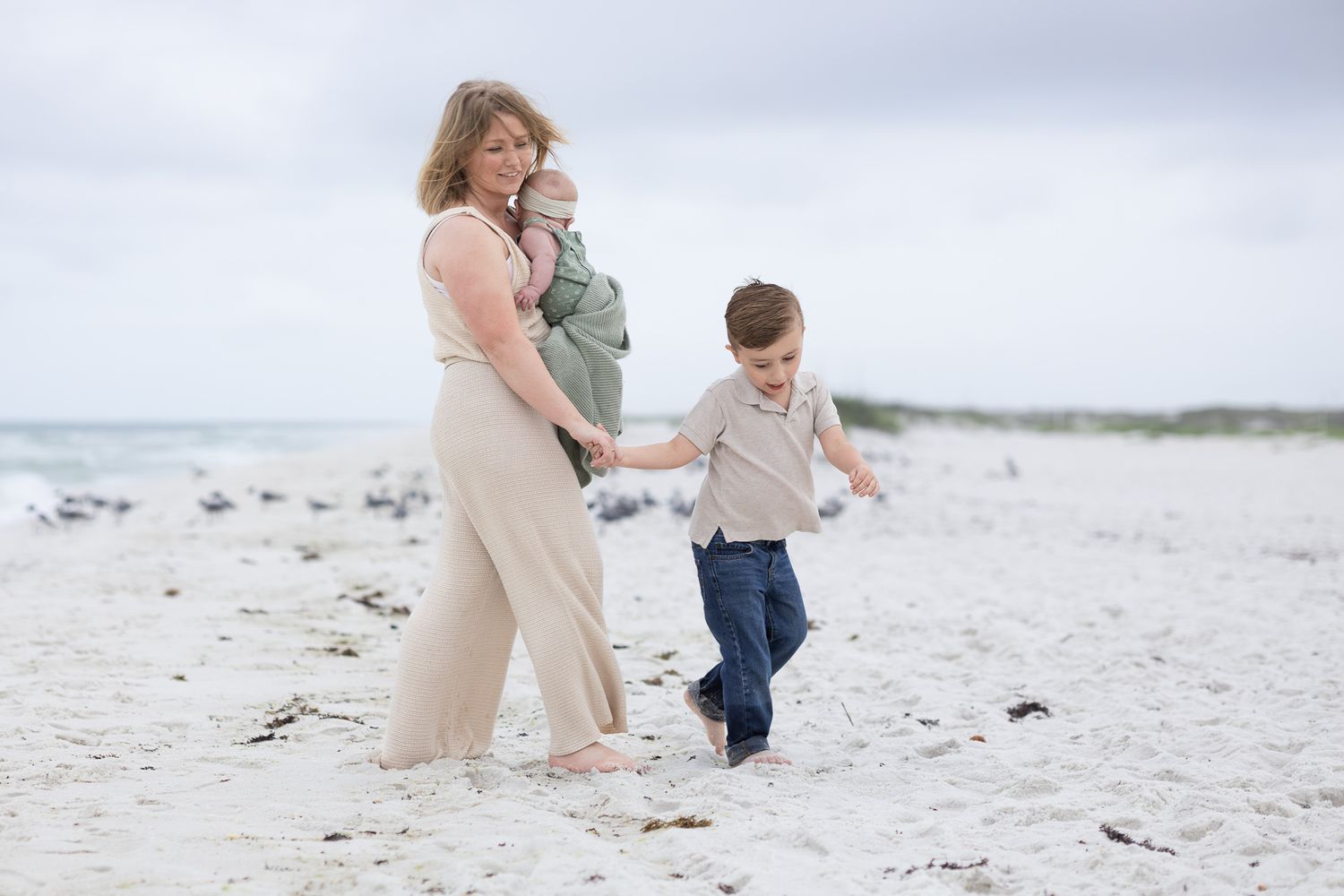 Mom and son walking together on the beach