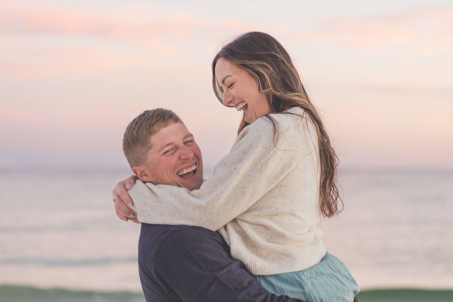 Couple embracing on the beach at sunset in Pensacola, FL