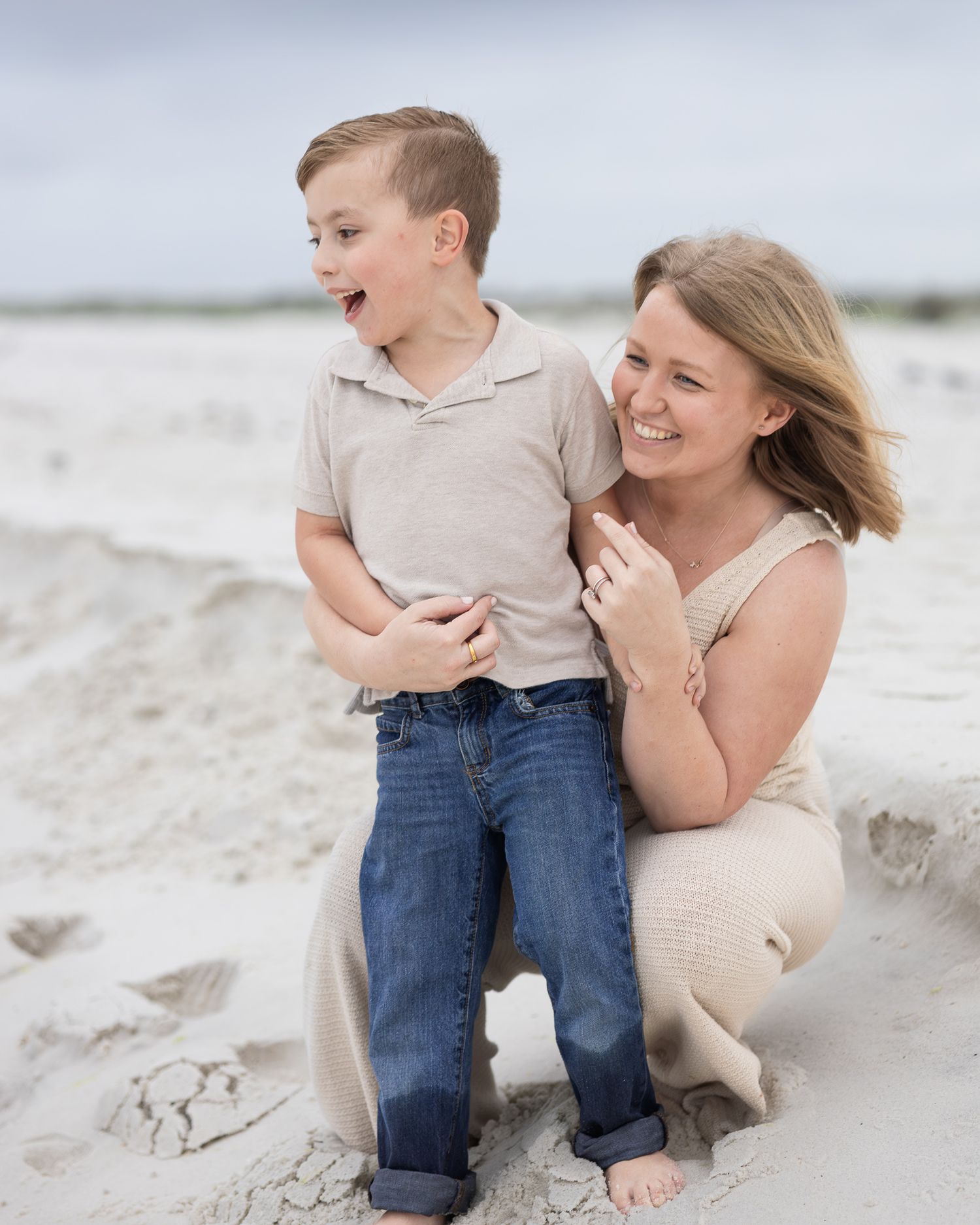 Mom laughing with her young son on the beach