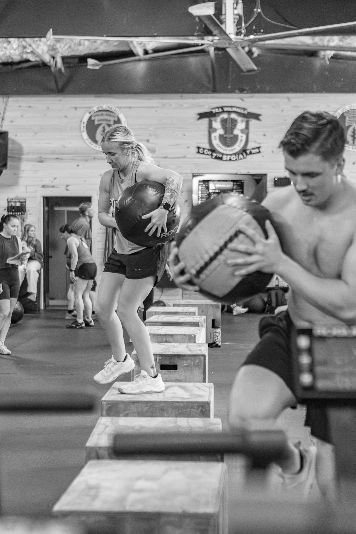 Black and white photo of athletes doing medicine ball exercises