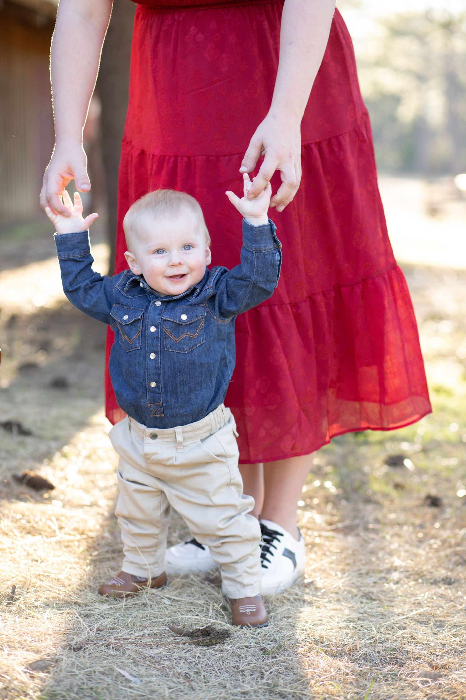 Baby boy taking steps while holding his mom's hands
