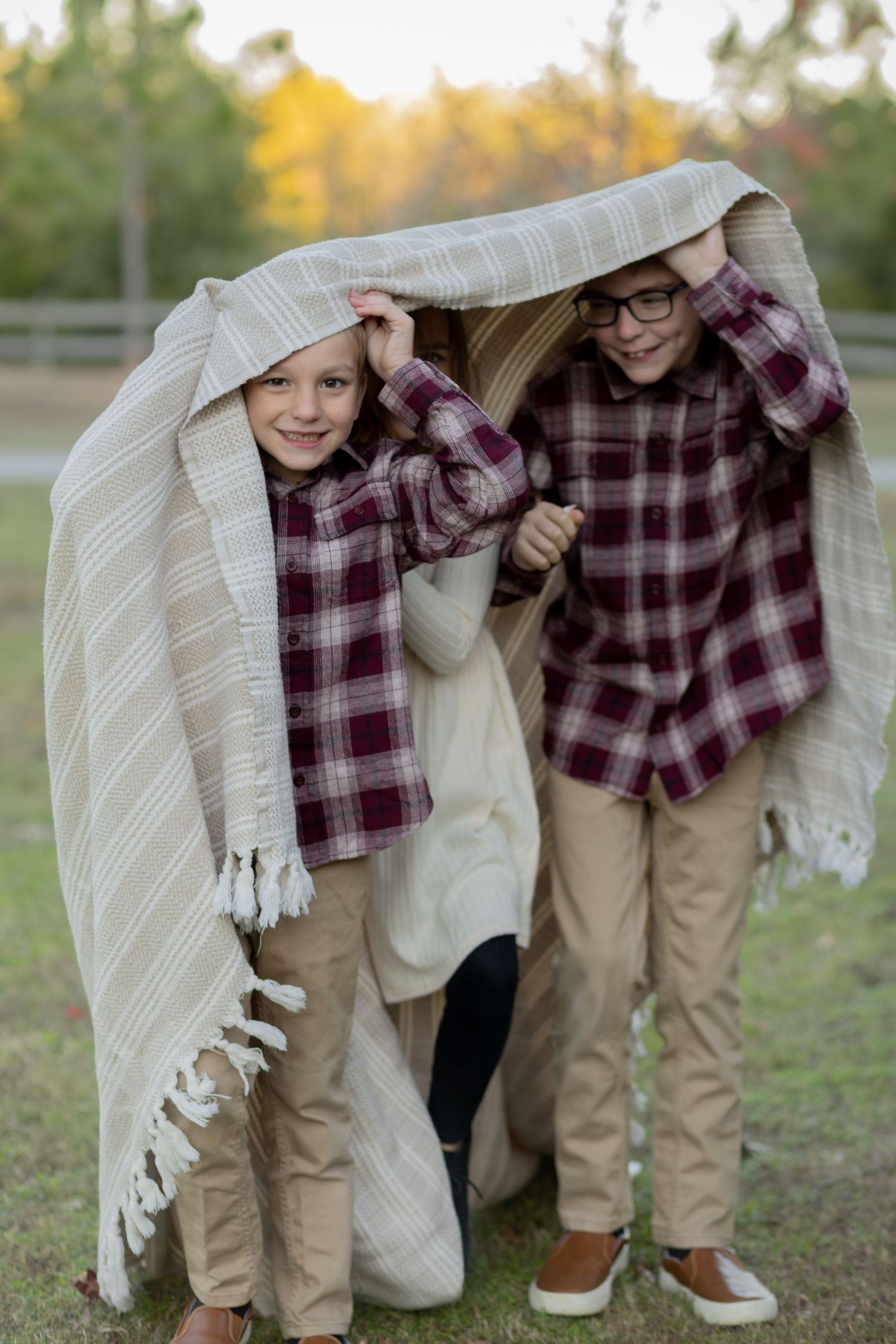 Kids peeking out from under a blanket during a fall family session