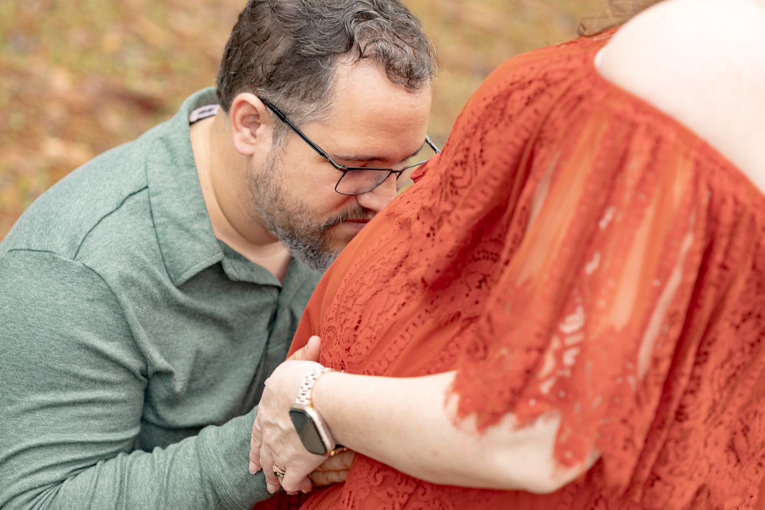 Dad-to-be leaning in close to mom during a maternity session in Milton, FL