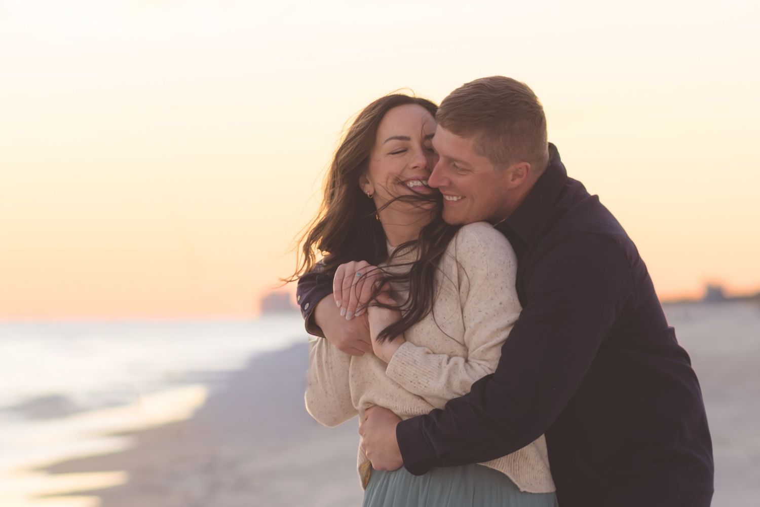 Couple cuddling on the beach at sunset