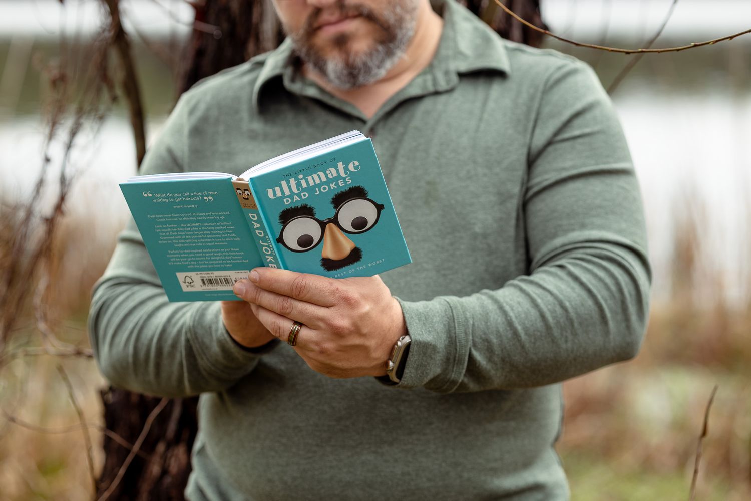 Dad-to-be reading a children's book during a maternity session at Bear Lake, Milton FL
