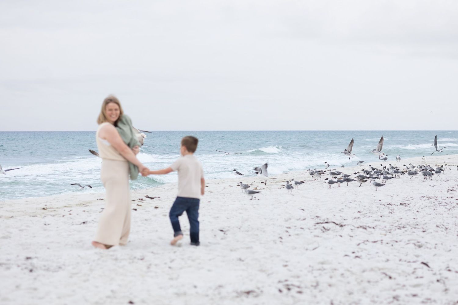 Mom and son playing among the seagulls on Pensacola Beach
