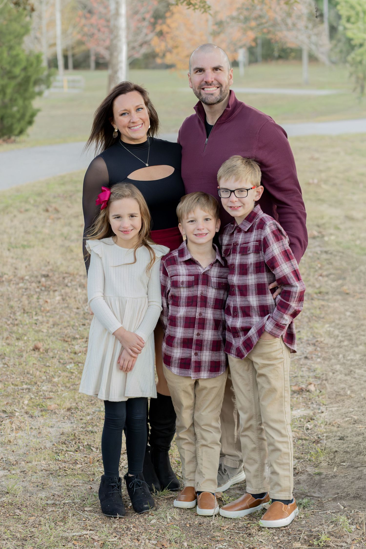 Family of five in coordinating plaid and neutrals for fall photos in the park