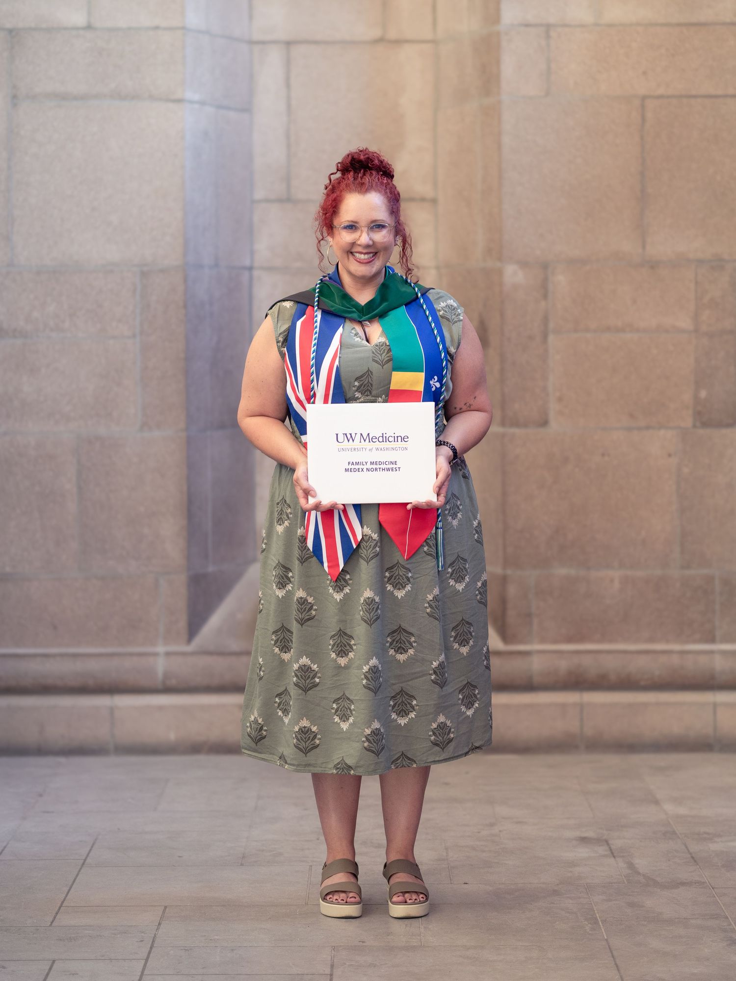 Smiling graduate holding her diploma cover, graduation milestone session