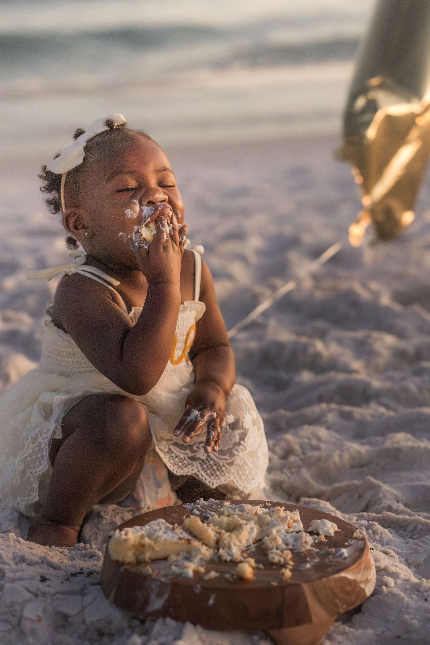 One-year-old enjoying her smash cake on the beach