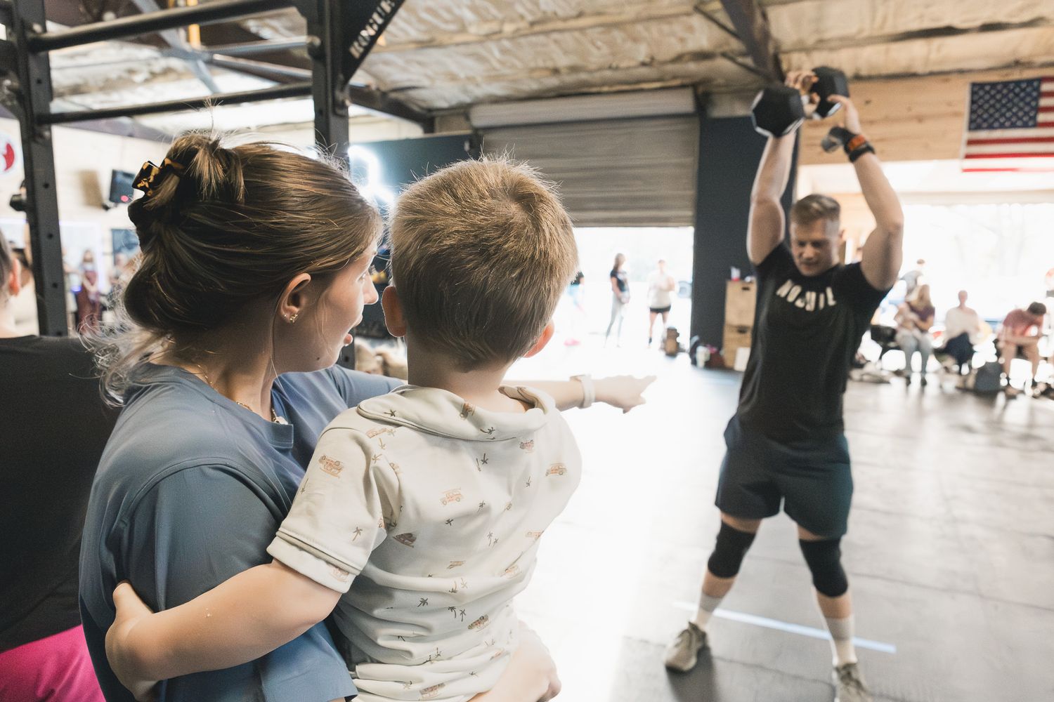 Mom holding her child while watching a gym event
