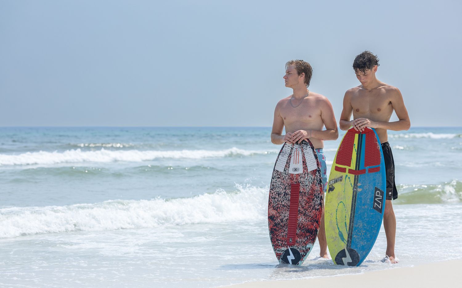 Two boys holding skimboards on Pensacola Beach