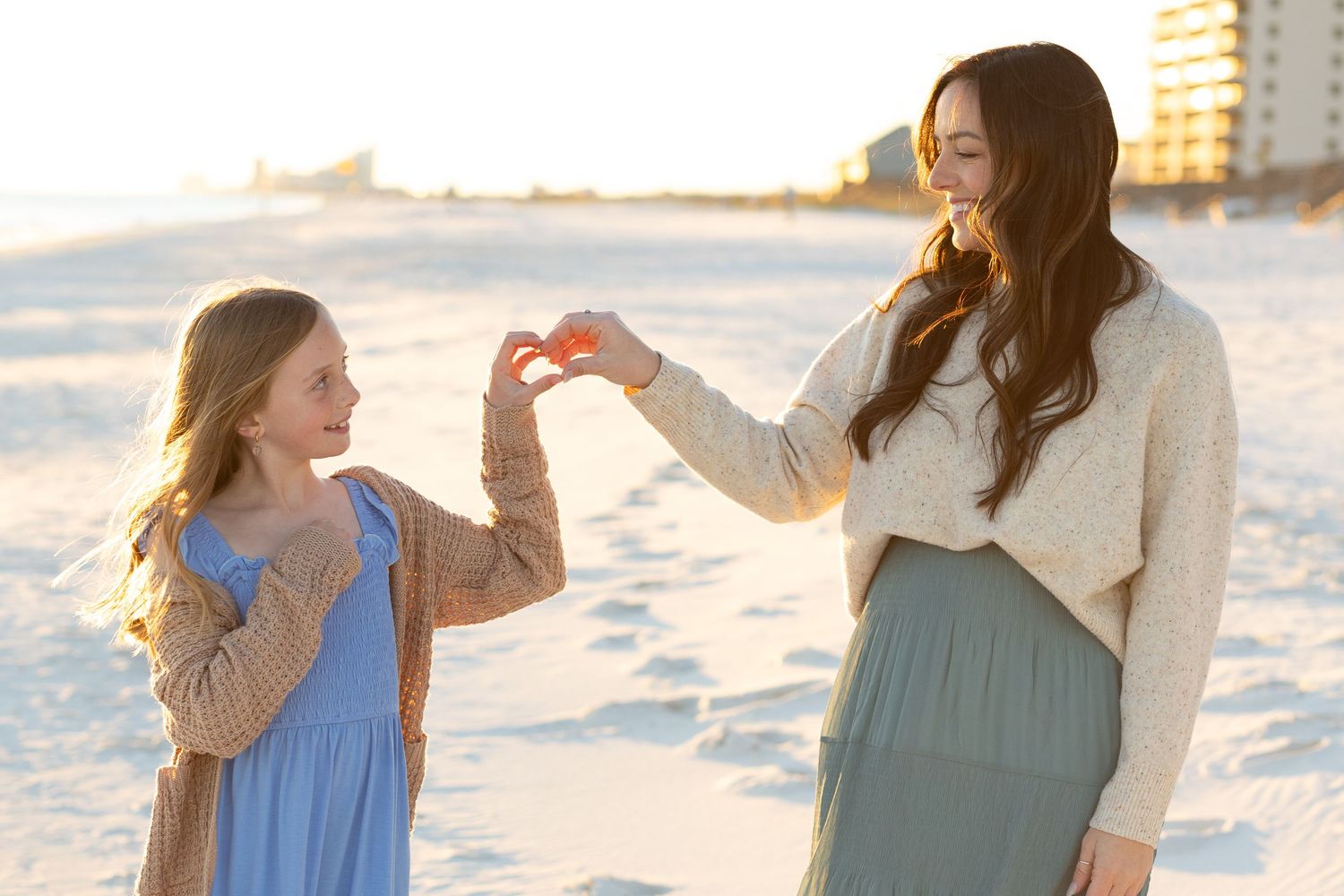Mother and daughter holding hands on the beach