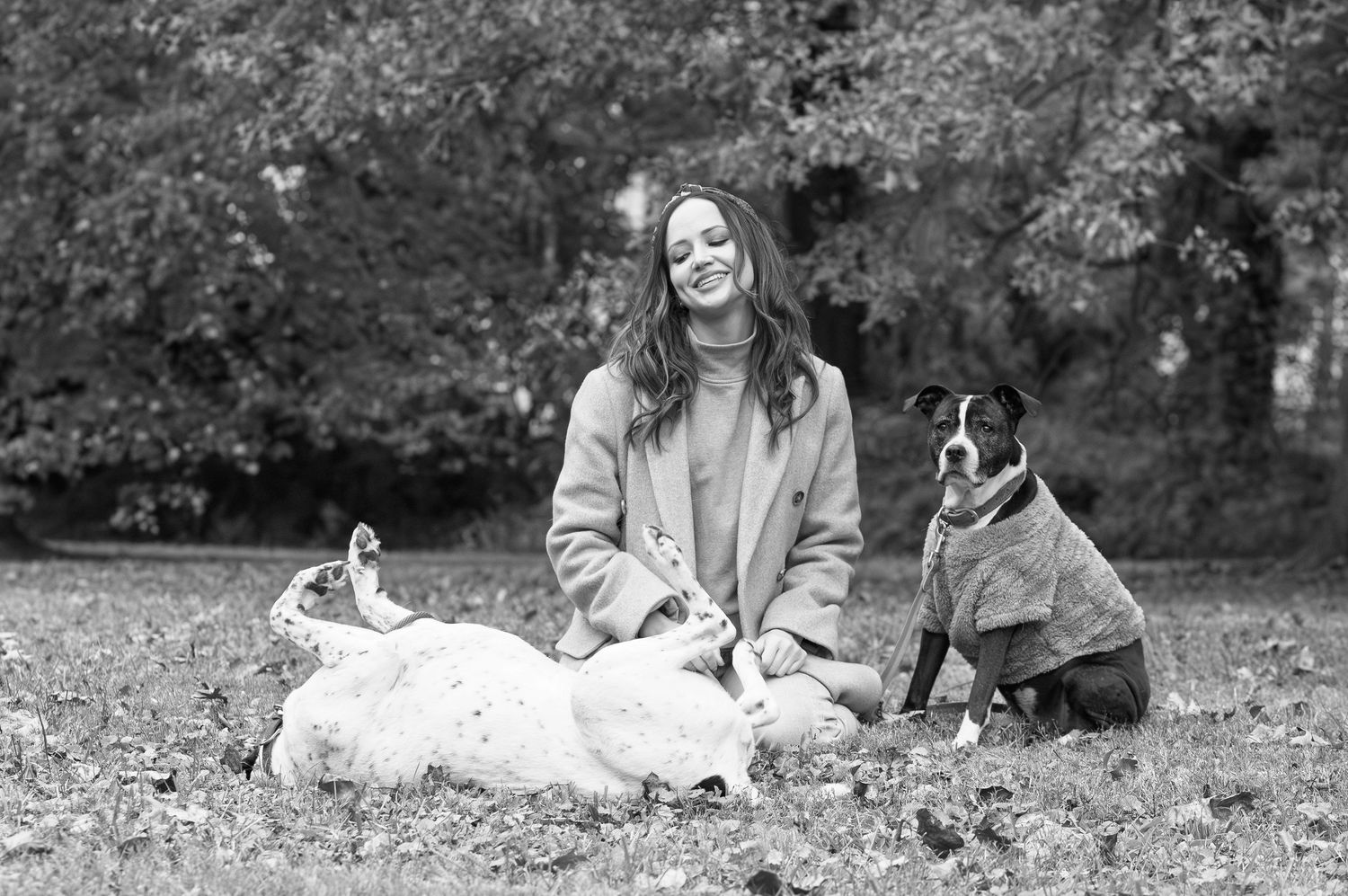 Woman sitting in the grass with her dogs