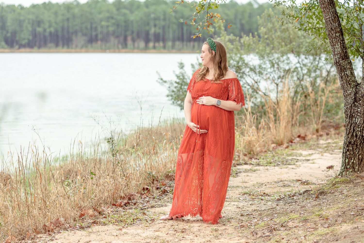 Pregnant mom in a flowing red dress by the lake at Bear Lake, Milton FL