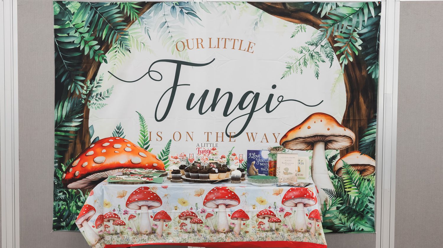 Woodland mushroom-themed baby shower backdrop and dessert table