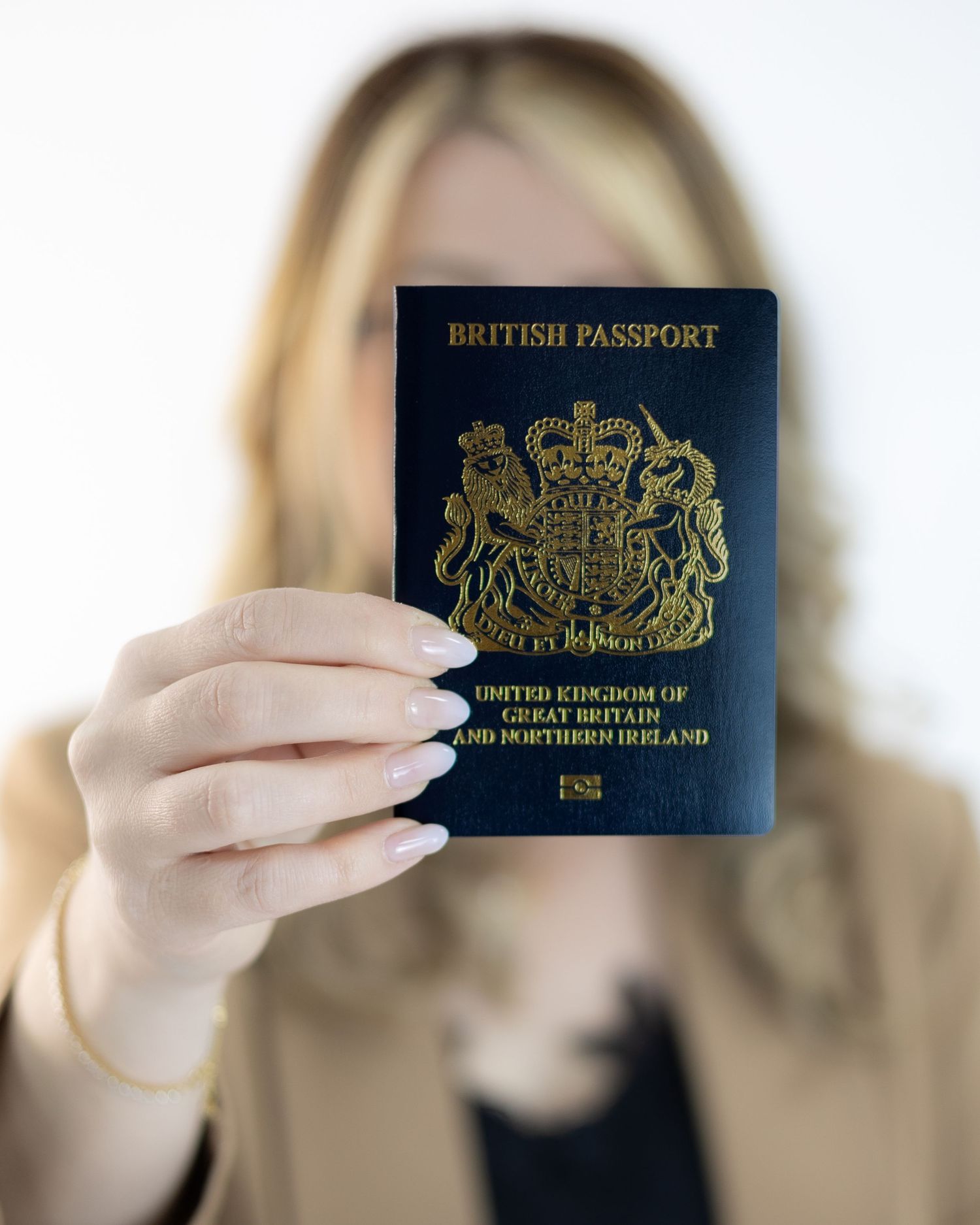 Woman holding British passport from United Kingdom of Great Britain and Northern Ireland toward camera. South London