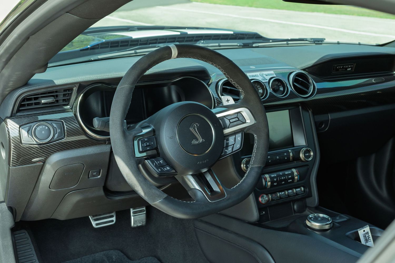 Ford Mustang Shelby GT500 interior dashboard with flat-bottom steering wheel and carbon fiber trim accents.