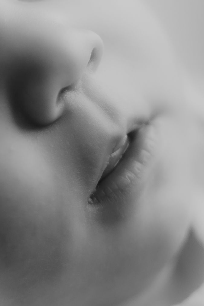Extreme black and white macro close-up of a newborn baby's delicate nose and lips.
