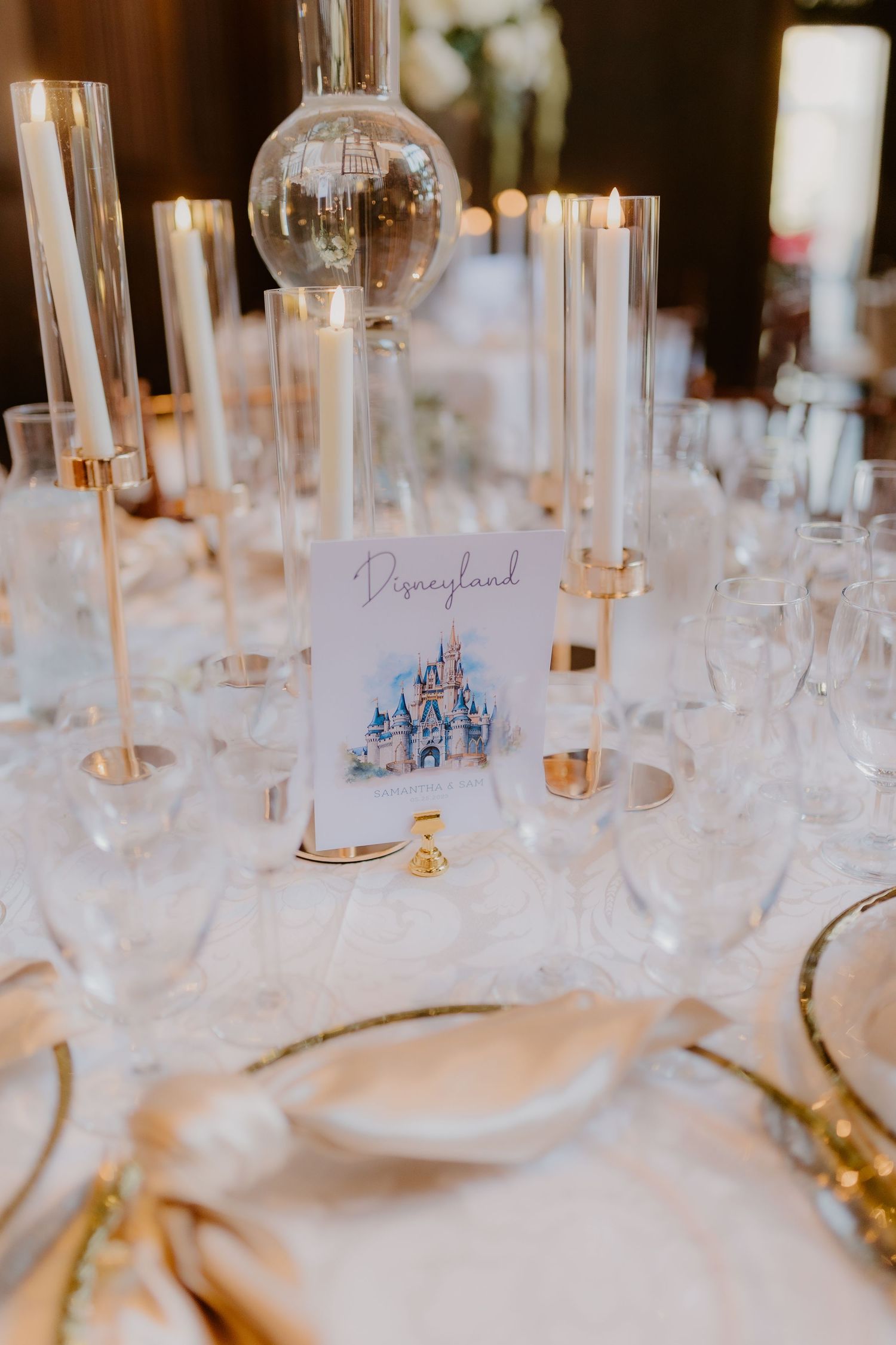Elegant reception table setting with Disneyland castle table number card surrounded by crystal candleholders.