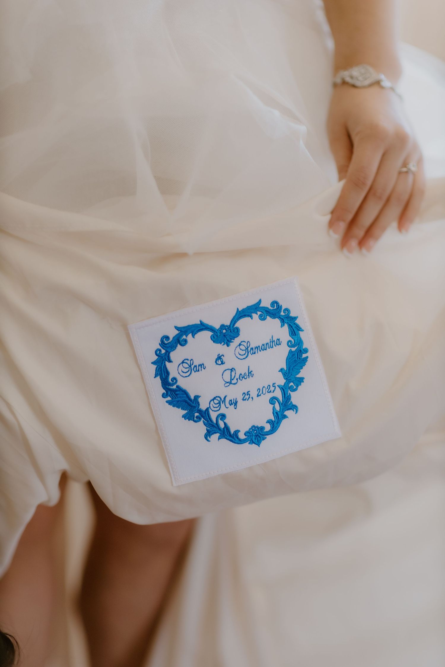 Wedding keepsake card with blue heart design reading Sam and Samantha Lock May 25, 2023 on bridal gown.