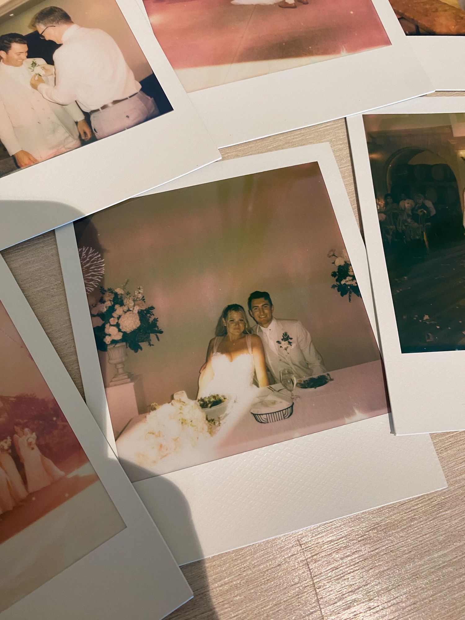 Vintage Polaroid photos of bride and groom sitting together at wedding reception table with flowers. film, wedding