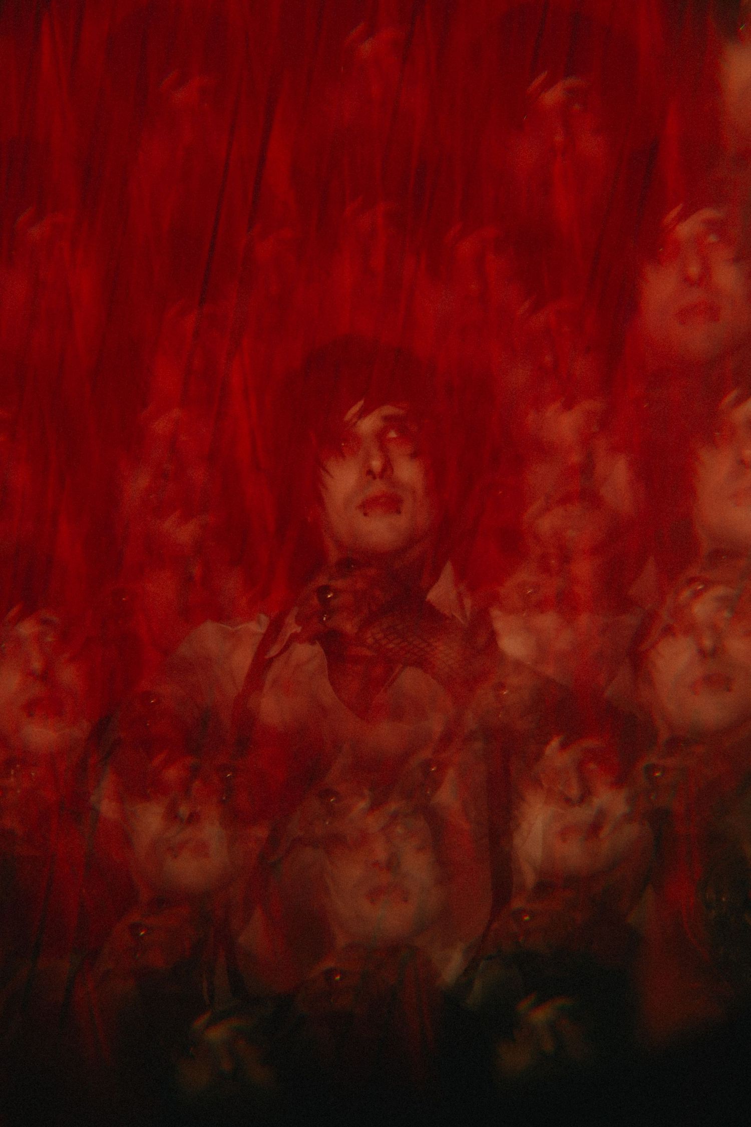 Surreal multiple exposure portrait of person surrounded by red dramatic lighting and ghostly reflections. Band guitar, multiple exposure