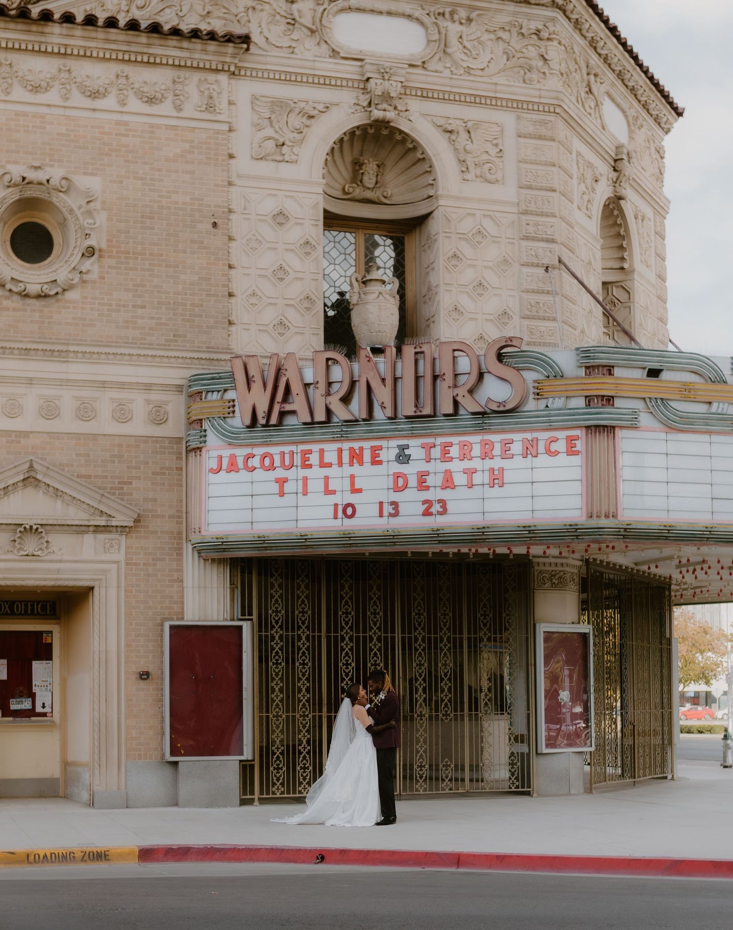 Wedding couple kissing under the Warner's Theatre marquee displaying Jacqueline and Terrence Till Death 10 13 23.