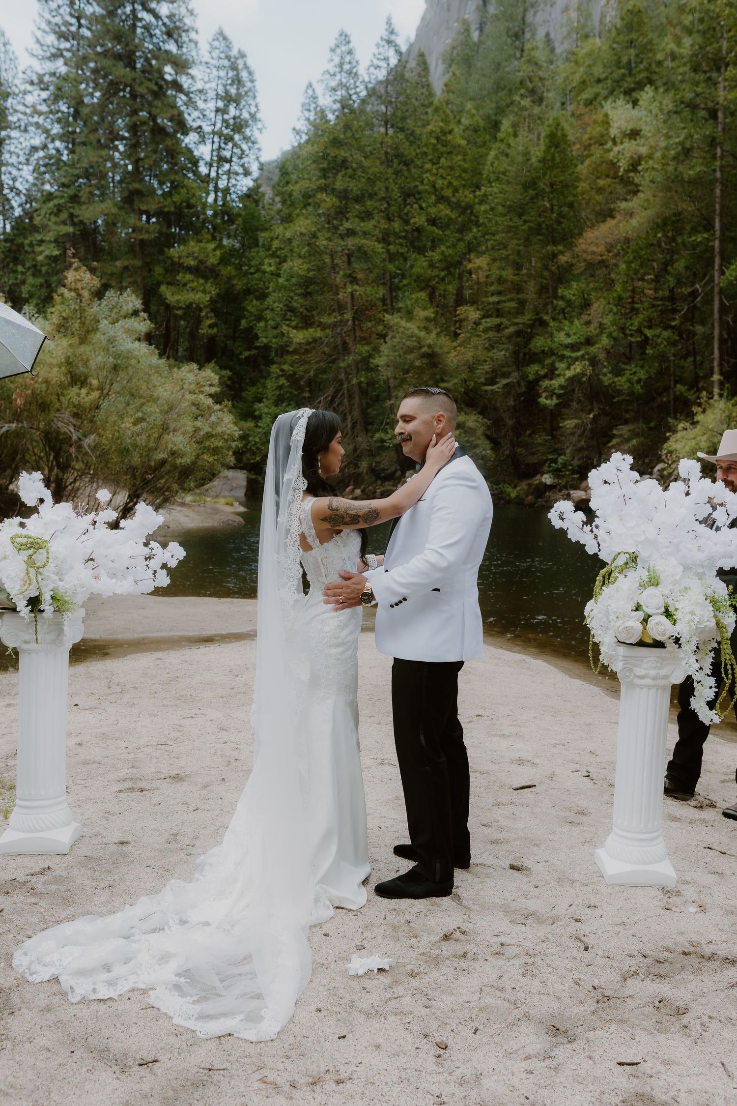 Bride and groom sharing a tender moment after exchanging vows at outdoor Yosemite riverside wedding ceremony.