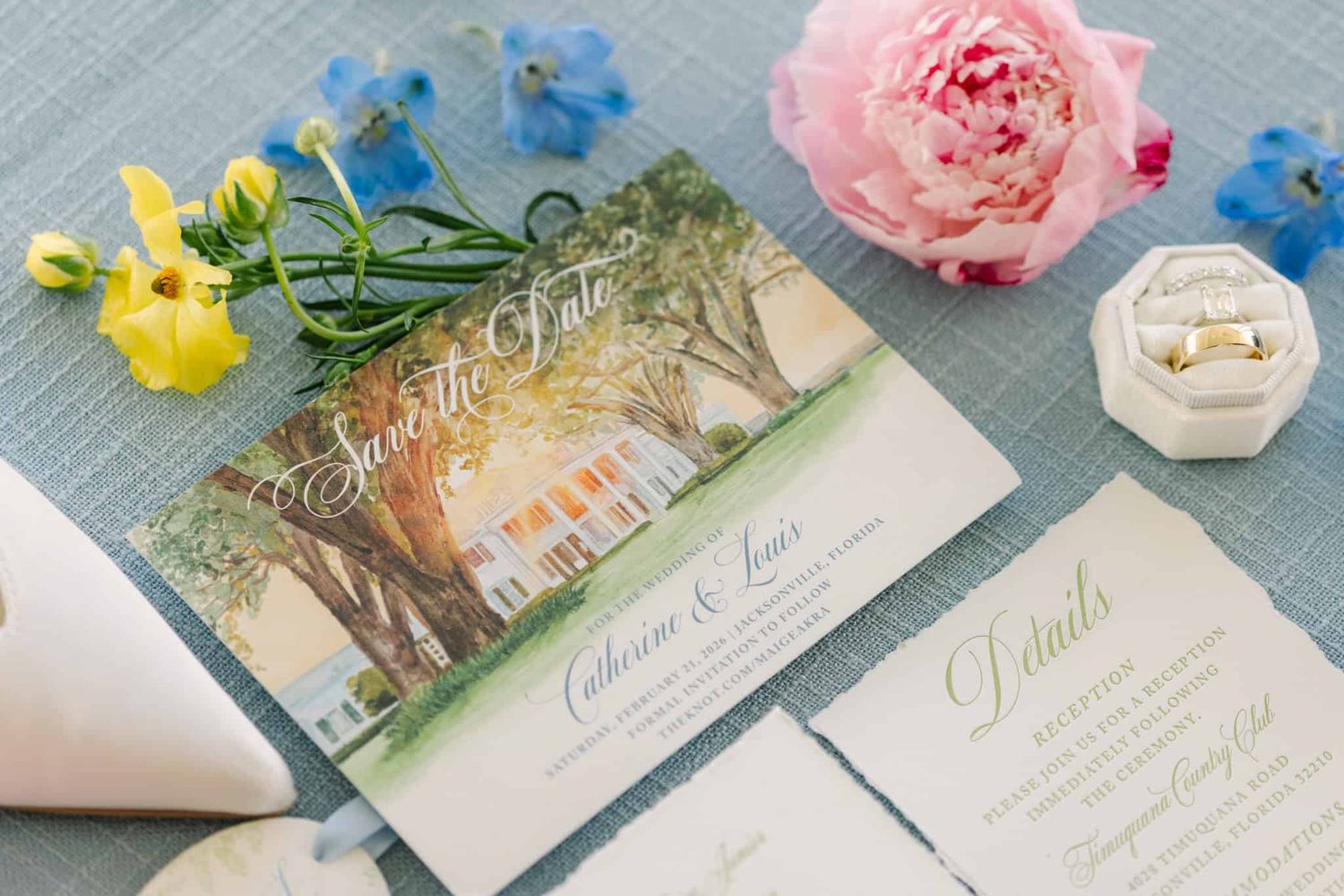 flat lay of wedding invitation with watercolor of venue and flowers