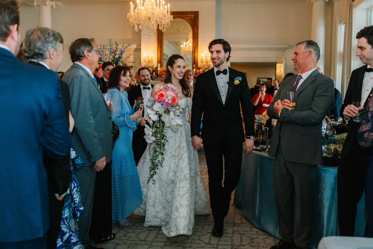 bride and groom walking into reception