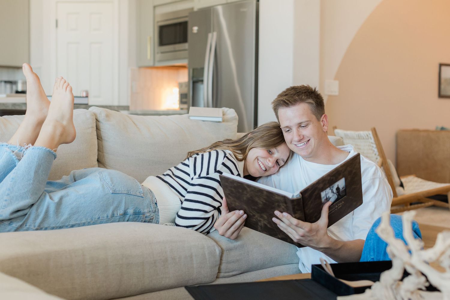 mom laying on dad on the couch looking at an album