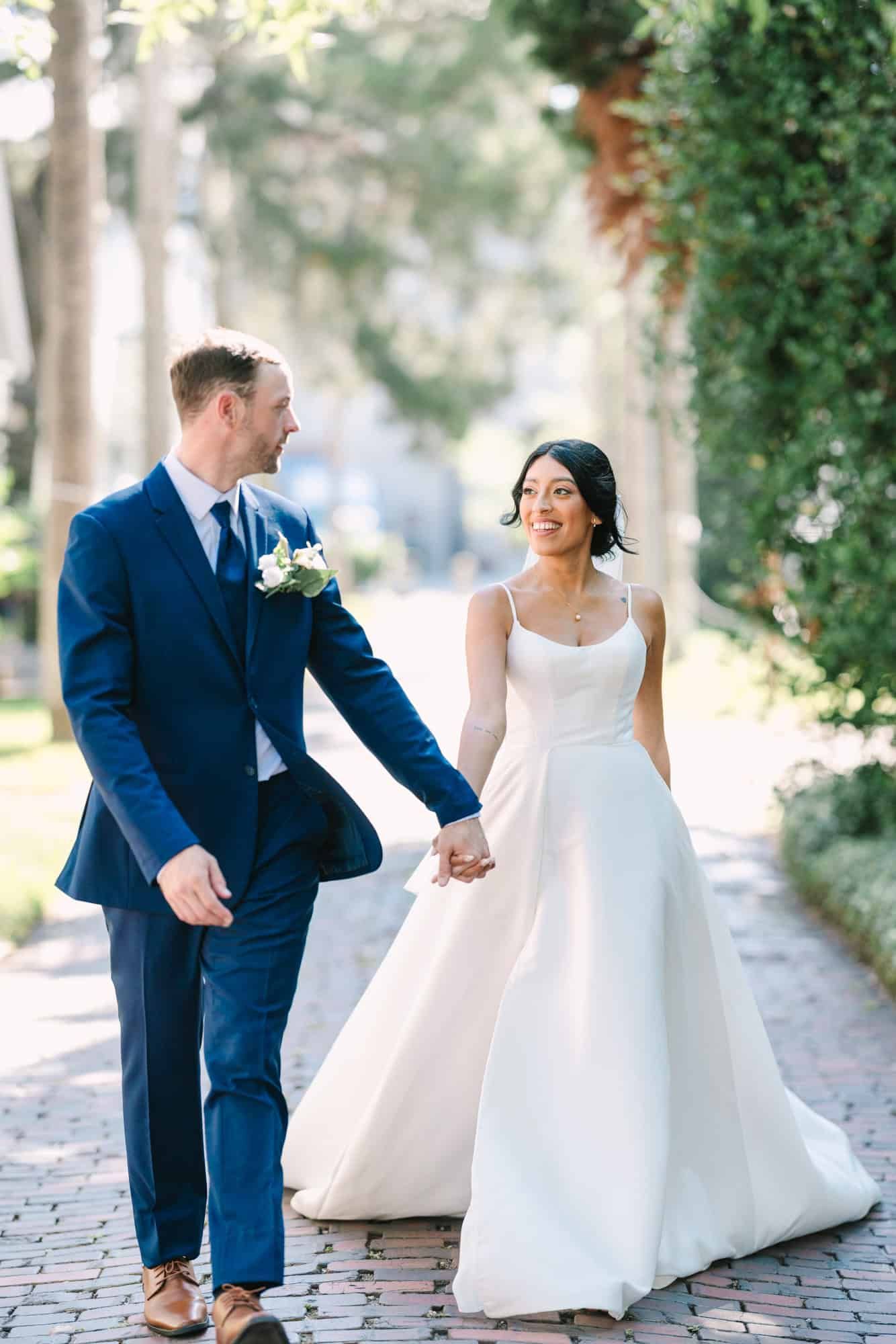 bride and groom walking looking at eachother and smiling
