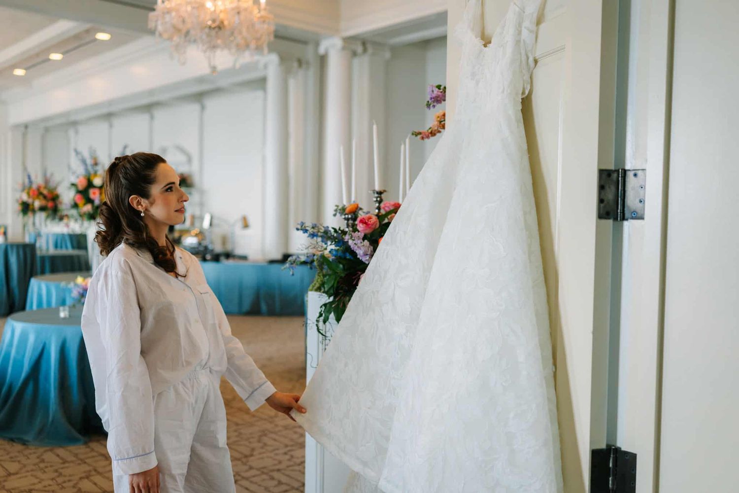 bride looking up at her dress as she gets ready for her wedding