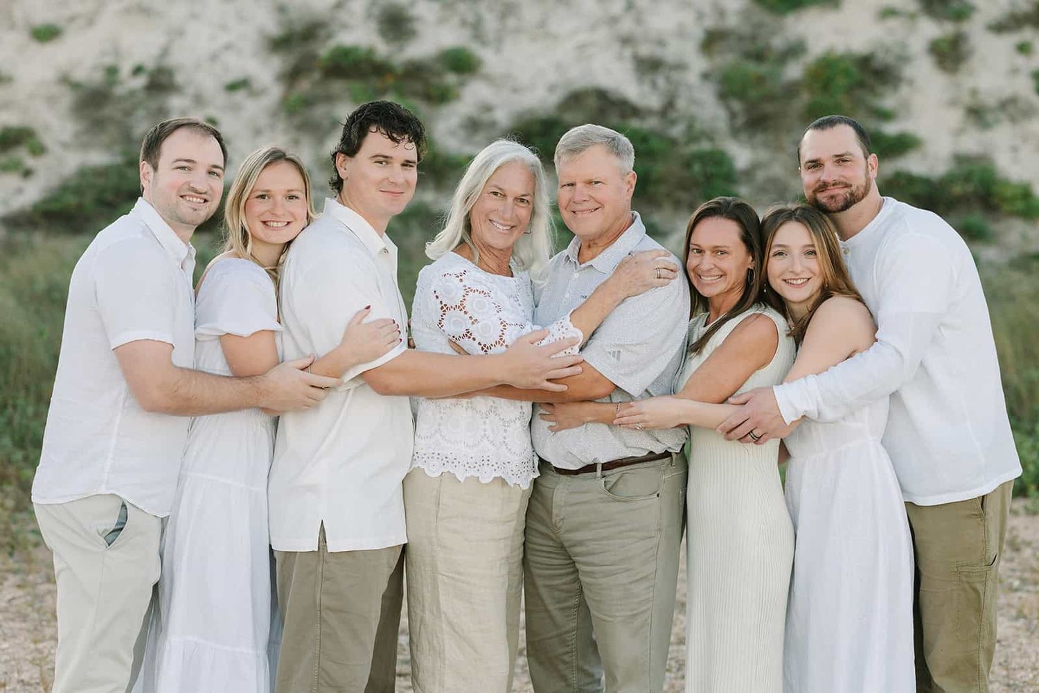 extended family at the beach giving a big group hug