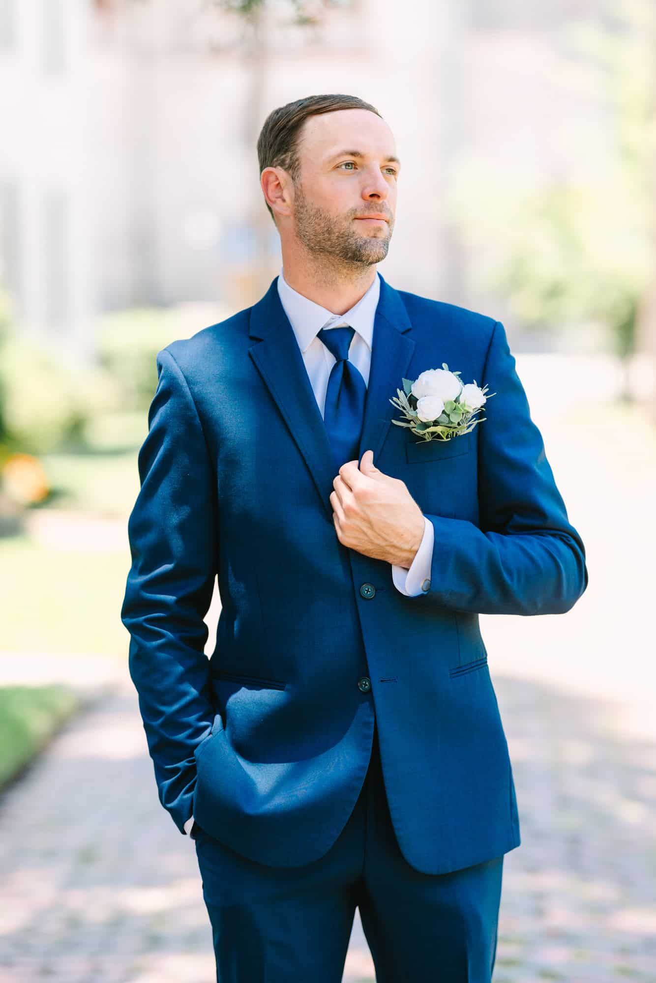 groom holding lapel and looking to the right