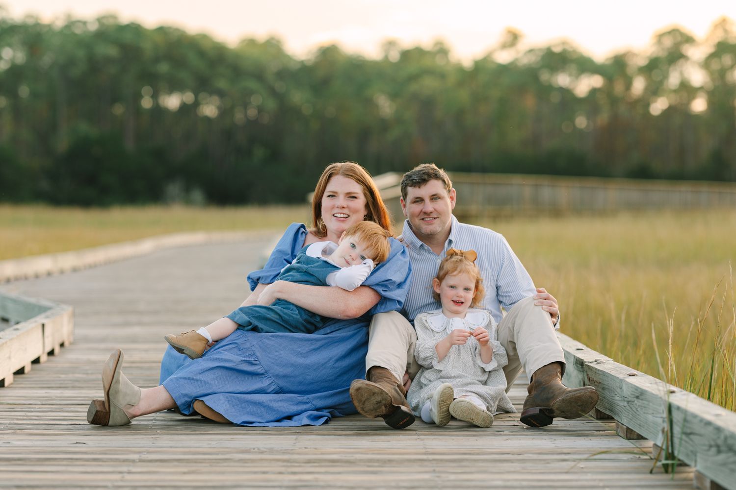 family of 4 sitting on the boardwalk in Jacksonville, fl. both toddlers and mom have red hair Jacksonville, fl photographer