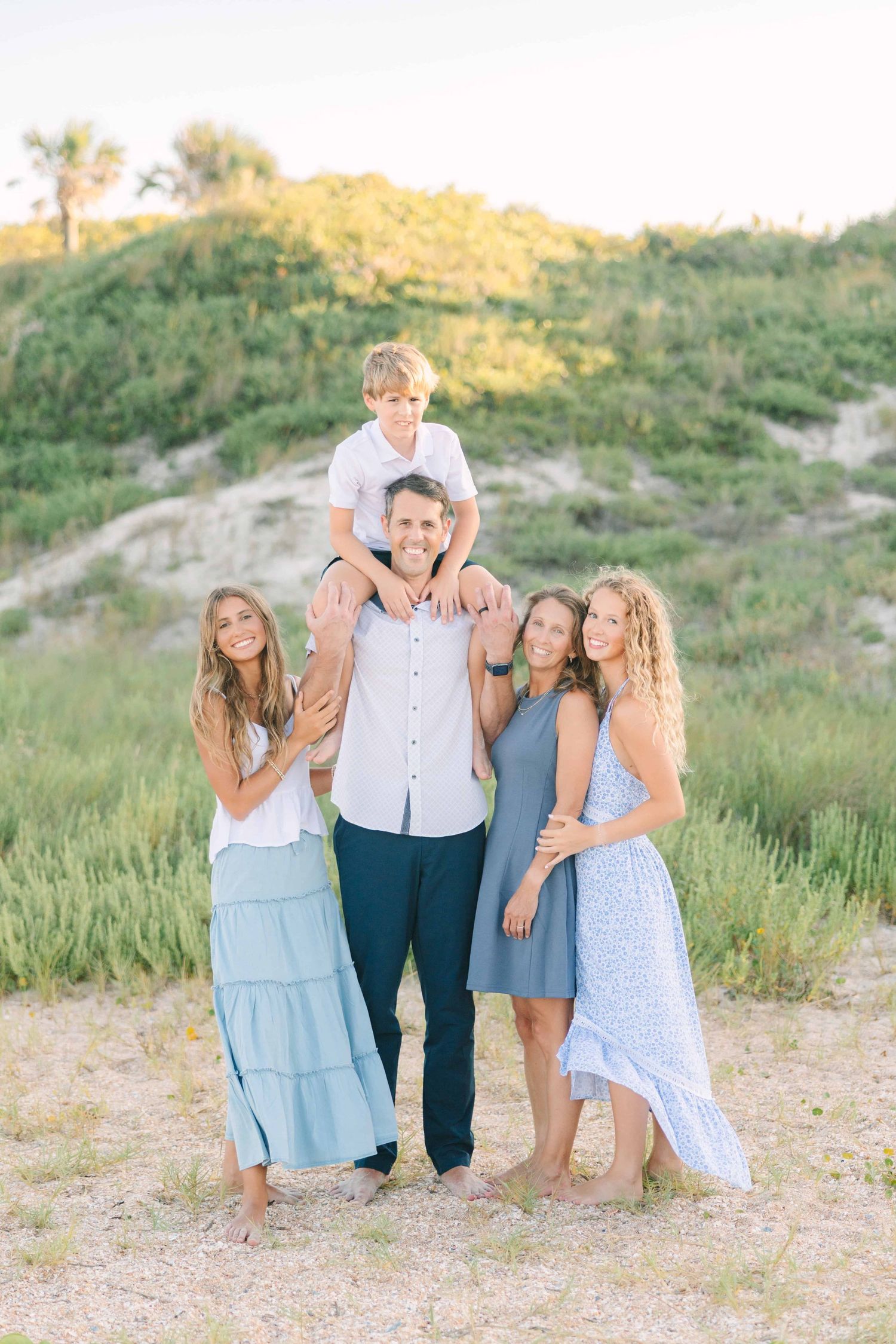 family on the beach with youngest son on dads shoulders