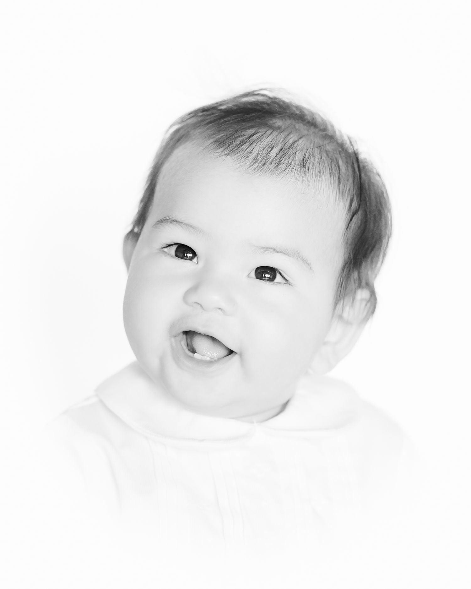 smiling baby boy looking up to the left in a black and white heirloom portrait style photo