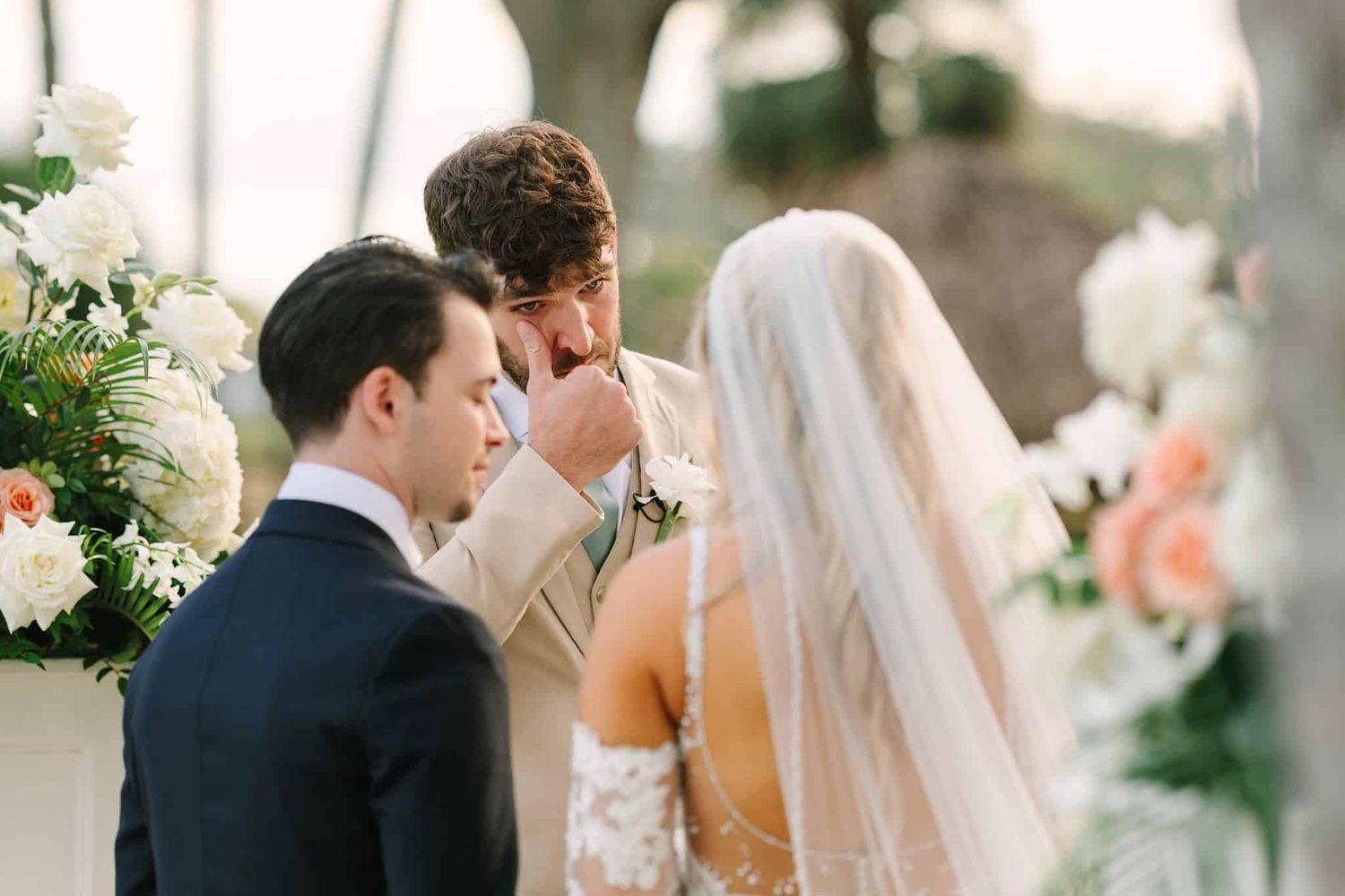 groom wiping a happy tear as he marries his bride