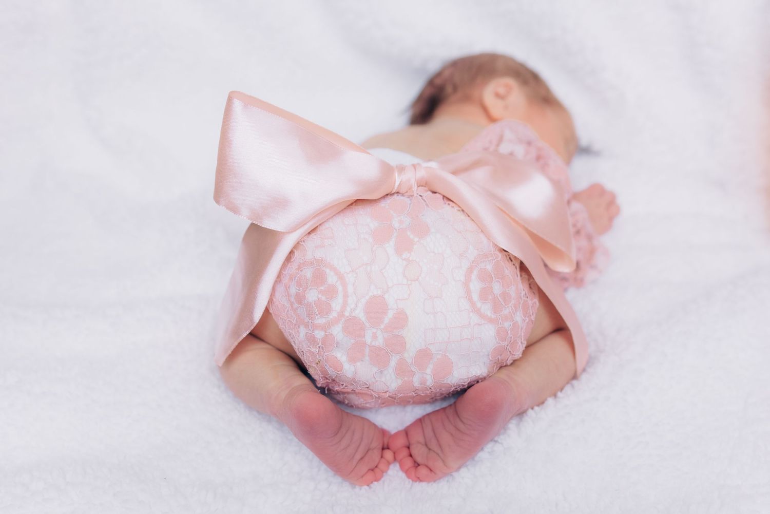 newborn baby butt with big pink bow and lace