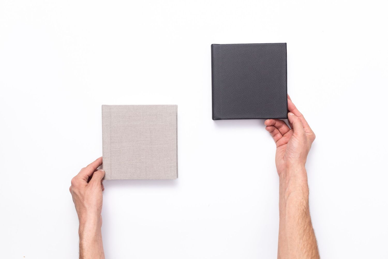 two smaller parent albums being held up by hands